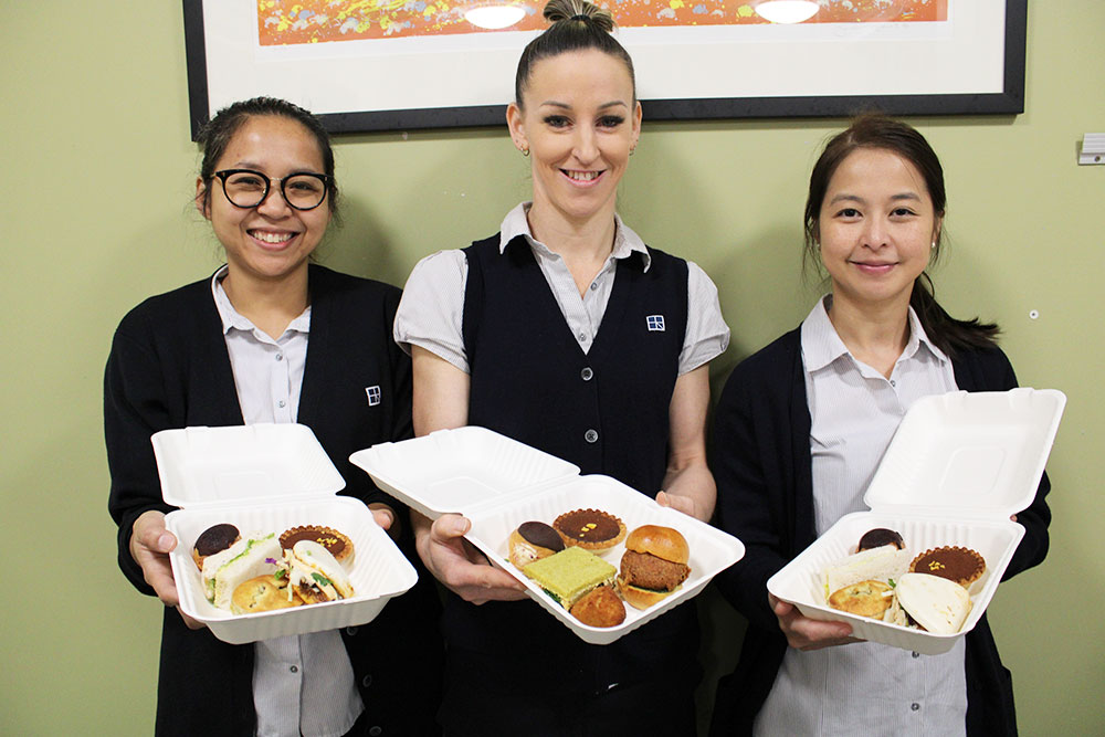 Glengarry Private Hospital staff Yupha Srichanhom, Leisha Latu and Wanlaya Niyomsin with their ‘high tea to go’ assortment boxes.